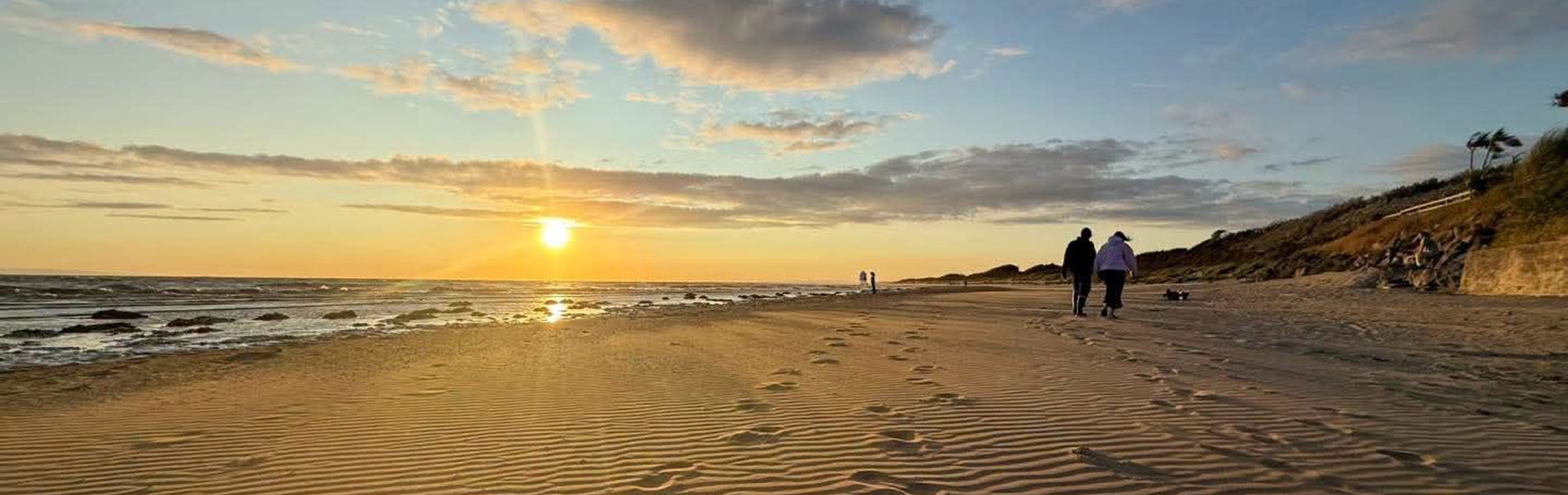 Foot prints in the sand and sunset in the distance at Burnham-on-Sea beach